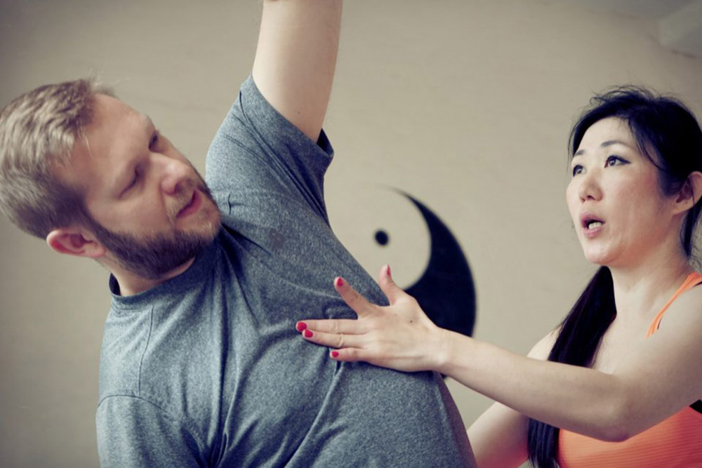 Yoga instructor assisting student