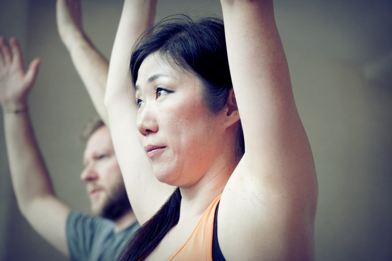 Woman in yoga pose arms raised